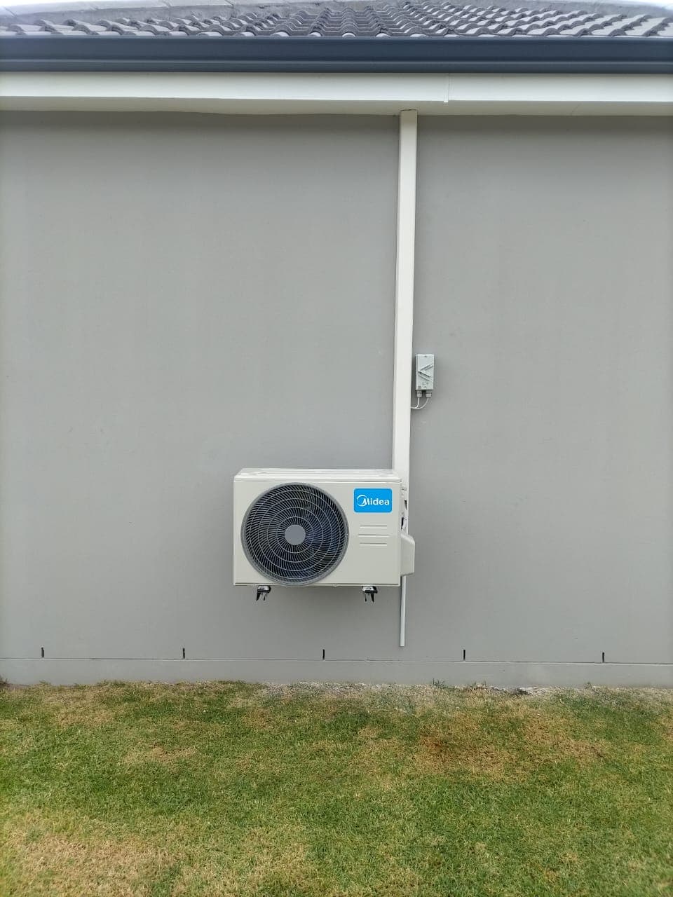 Outdoor split condenser mounted on a residential wall
